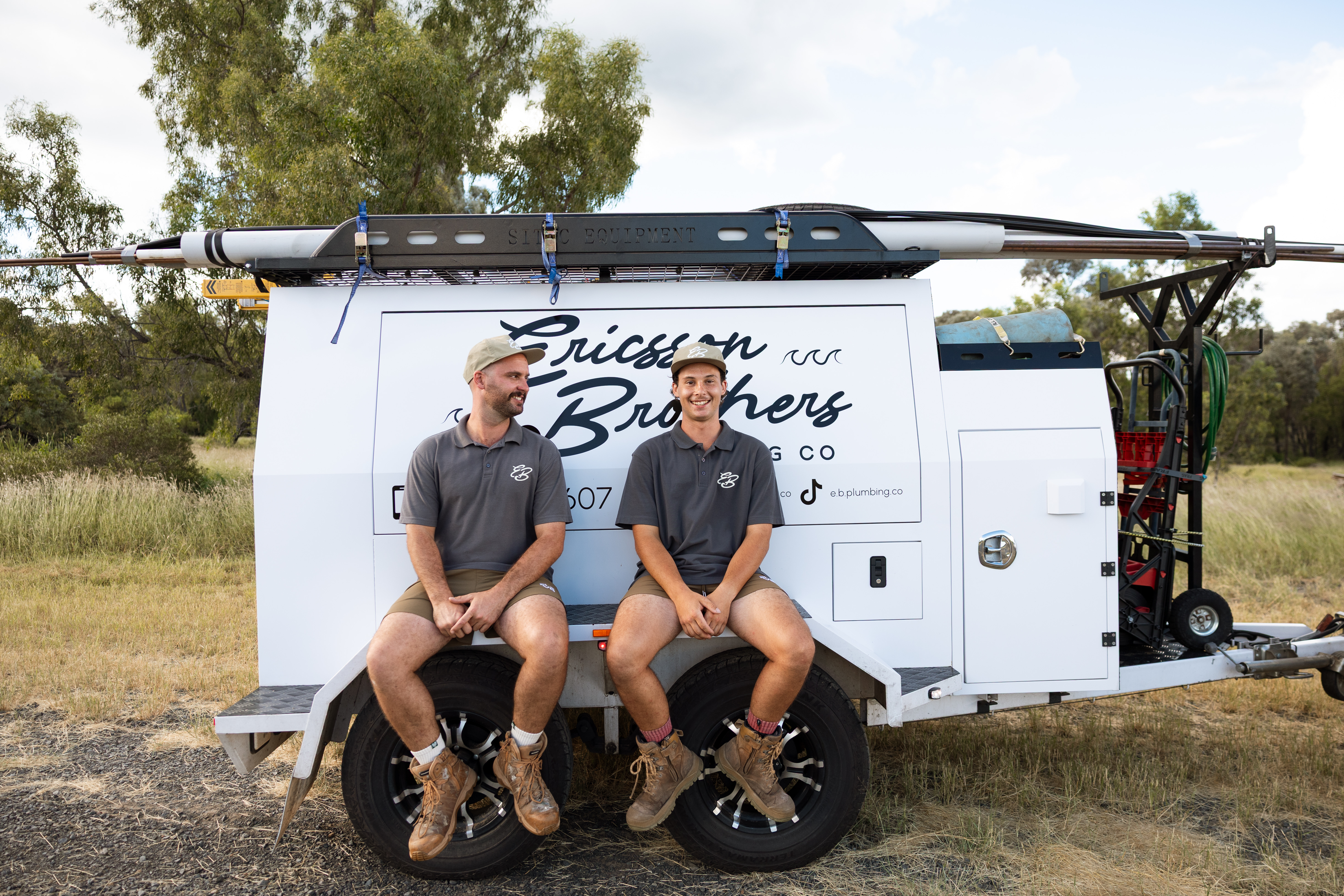 The Ericsson Brothers sitting on their work trailer